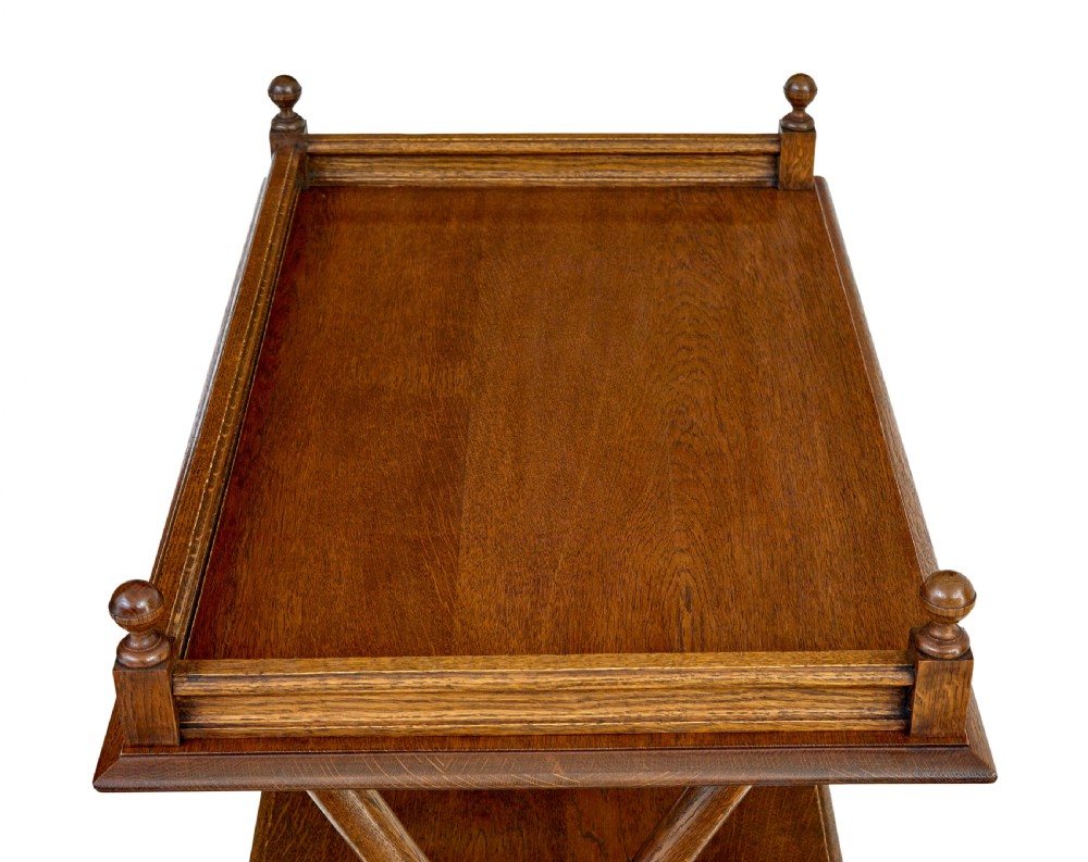 A 19th-century oak butlers tray table featuring a gallery-edged top tray with corner finials, a lower tiered shelf, and turned X-frame folding legs. View VII