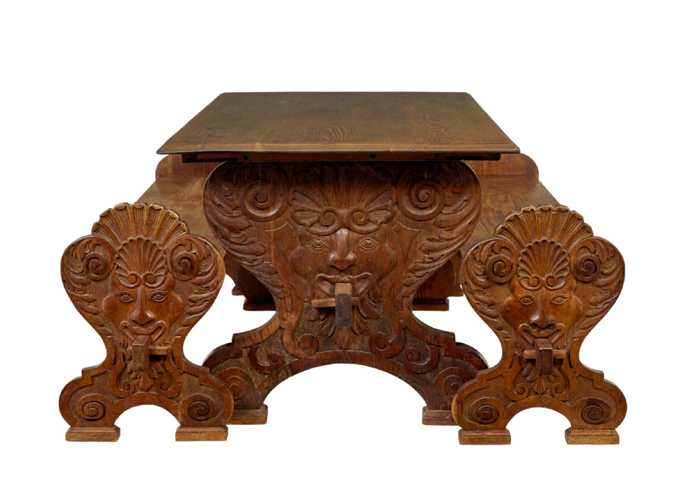 A 19th-century carved oak dining table flanked by two matching wooden benches with relief carvings on the trestle end supports. View III