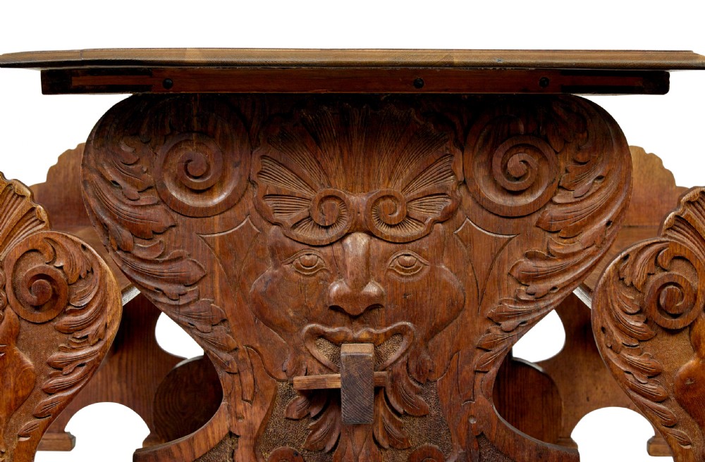 A 19th-century carved oak dining table flanked by two matching wooden benches with relief carvings on the trestle end supports. View IV