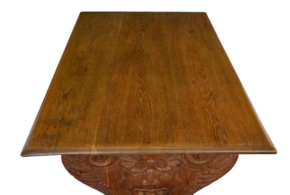 A 19th-century carved oak dining table flanked by two matching wooden benches with relief carvings on the trestle end supports. View V