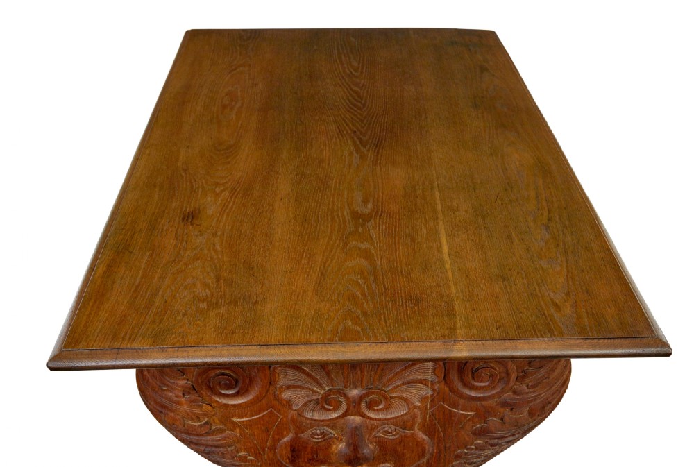 A 19th-century carved oak dining table flanked by two matching wooden benches with relief carvings on the trestle end supports. View VI