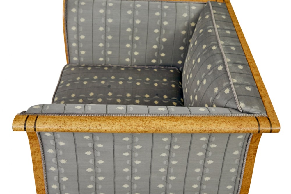 A pair of Art Deco armchairs featuring flared burr birch frames, grey upholstered cushions with a pattern motif, and ebonised carved feet. View X