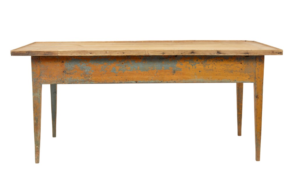 A mid 19th-century Swedish pine bakers table featuring two drawers, tapered square legs, and a distressed blue painted finish with a scrubbed wooden top. View V