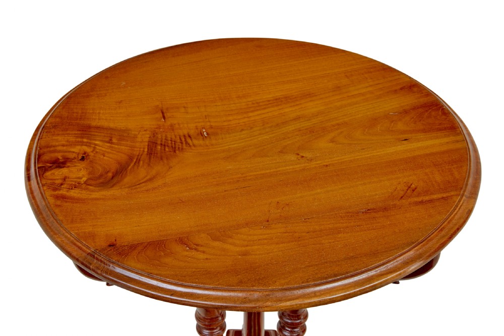 A circular carved teak side table featuring three curved legs and a central turned column on a triangular plinth base. View III