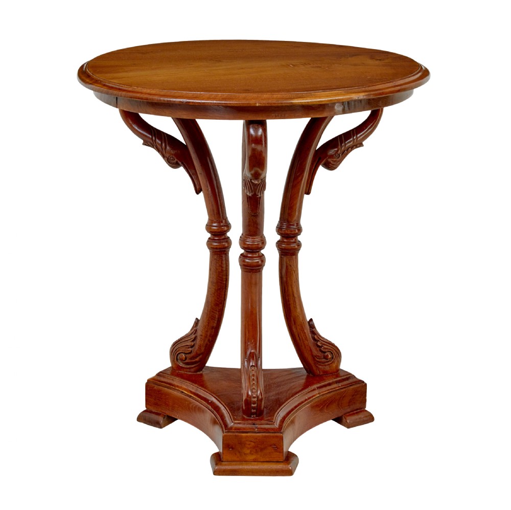 A circular carved teak side table featuring three curved legs and a central turned column on a triangular plinth base. View VI