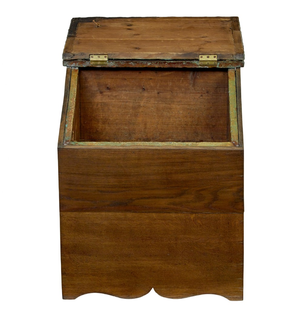 A 19th-century oak sloped-top storage box featuring an embossed brass lid panel depicting figures on horseback and a scalloped wooden base. View III