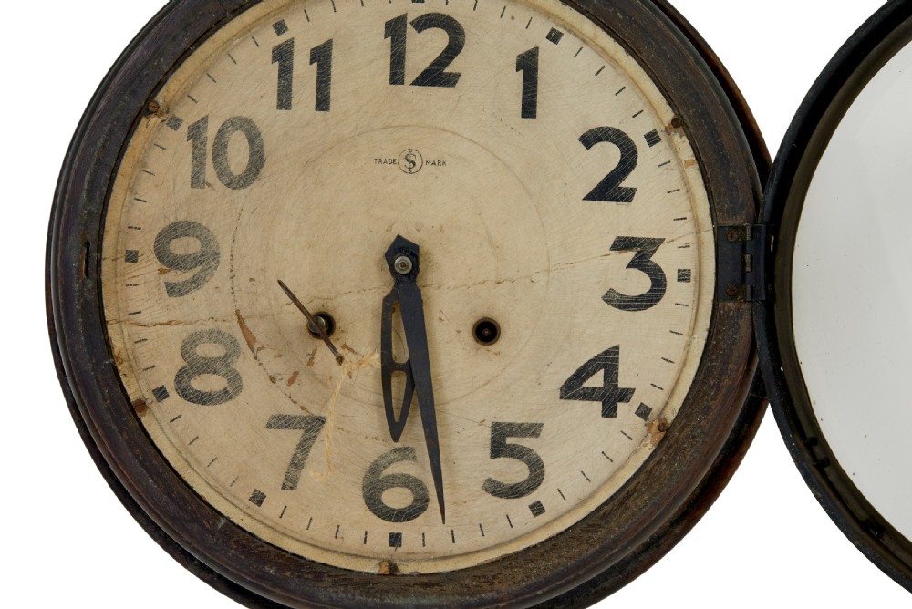 A circular vintage Japanese wall clock featuring a dark wooden bezel and an off-white dial with black Arabic numerals. View V