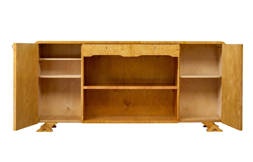A low Scandinavian Art Deco open bookcase in golden burr elm with rounded upper corners, flanked cupboards, open central shelves, and sculpted feet. View III
