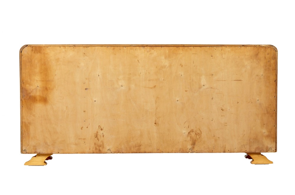 A low Scandinavian Art Deco open bookcase in golden burr elm with rounded upper corners, flanked cupboards, open central shelves, and sculpted feet. View V
