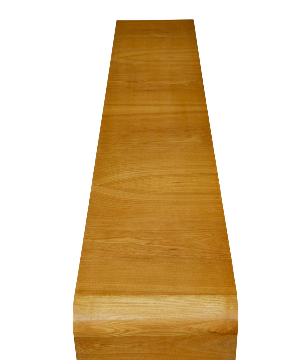 A low Scandinavian Art Deco open bookcase in golden burr elm with rounded upper corners, flanked cupboards, open central shelves, and sculpted feet. View VII