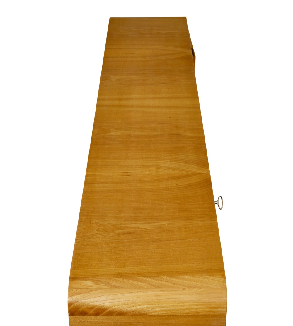 A low Scandinavian Art Deco open bookcase in golden burr elm with rounded upper corners, flanked cupboards, open central shelves, and sculpted feet. View VIII