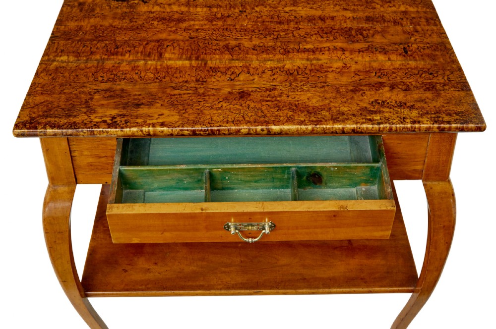 A 19th-century fruitwood and alder occasional table featuring curved legs, a single drawer with a brass handle, a lower shelf, and a figured wood top. View IV