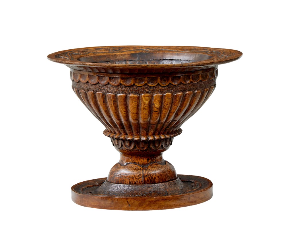 A 19th-century carved oak pedestal bowl featuring deep fluted sides, carved scrollwork along the rim, and a turned circular base. View III