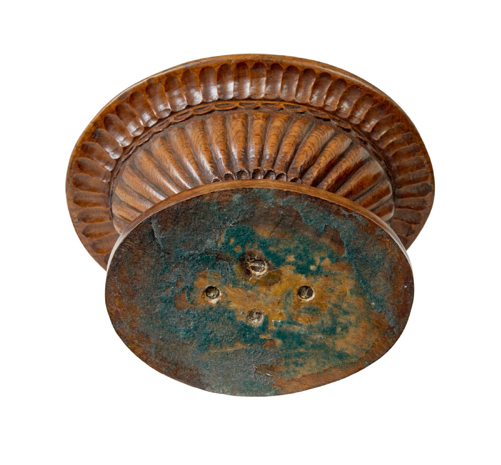 A 19th-century carved oak pedestal bowl featuring deep fluted sides, carved scrollwork along the rim, and a turned circular base. View VI