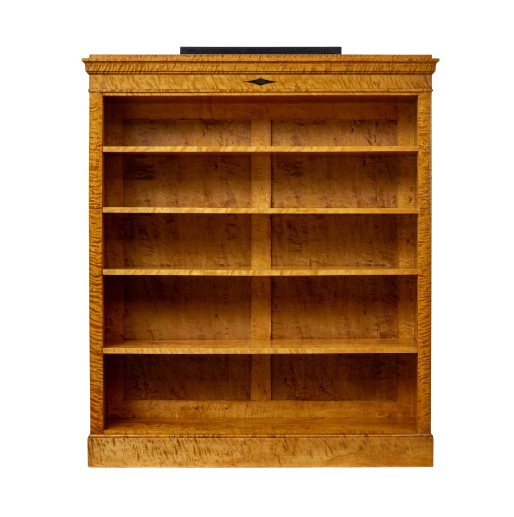 An early 20th-century Swedish Empire Revival open bookcase crafted from golden satin birch with a stepped cornice and ebonised diamond motif. View II