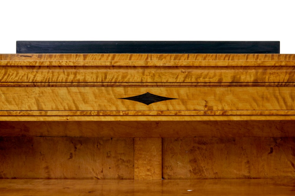 An early 20th-century Swedish Empire Revival open bookcase crafted from golden satin birch with a stepped cornice and ebonised diamond motif. View VII
