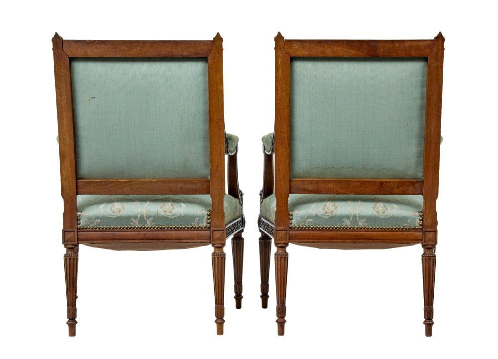A pair of 19th-century French carved walnut armchairs featuring sage green floral tapestry upholstery, fluted legs, and padded armrests. View IV