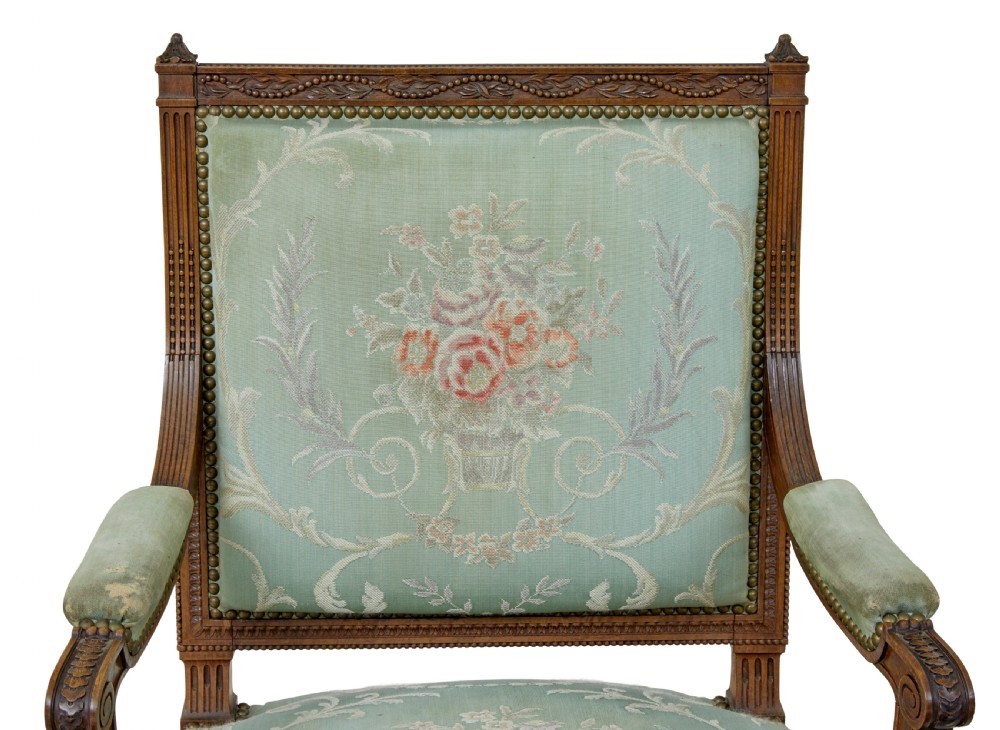 A pair of 19th-century French carved walnut armchairs featuring sage green floral tapestry upholstery, fluted legs, and padded armrests. View VII