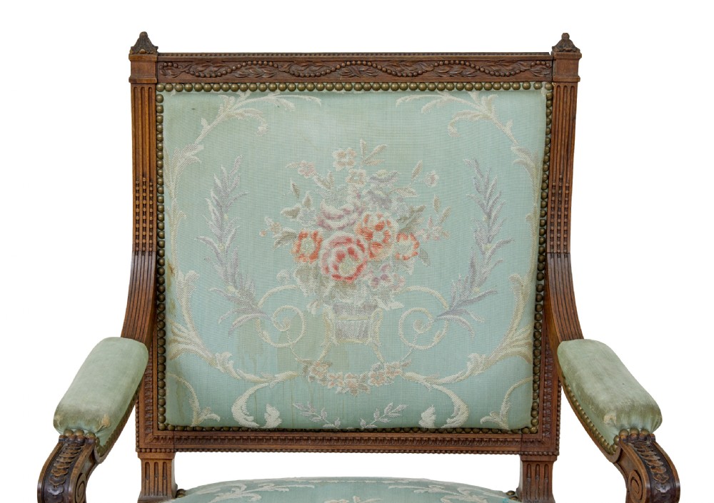 A pair of 19th-century French carved walnut armchairs featuring sage green floral tapestry upholstery, fluted legs, and padded armrests. View VIII