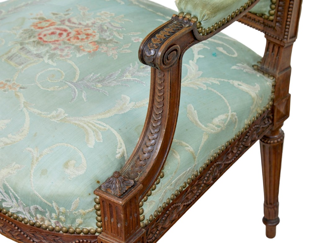 A pair of 19th-century French carved walnut armchairs featuring sage green floral tapestry upholstery, fluted legs, and padded armrests. View IX