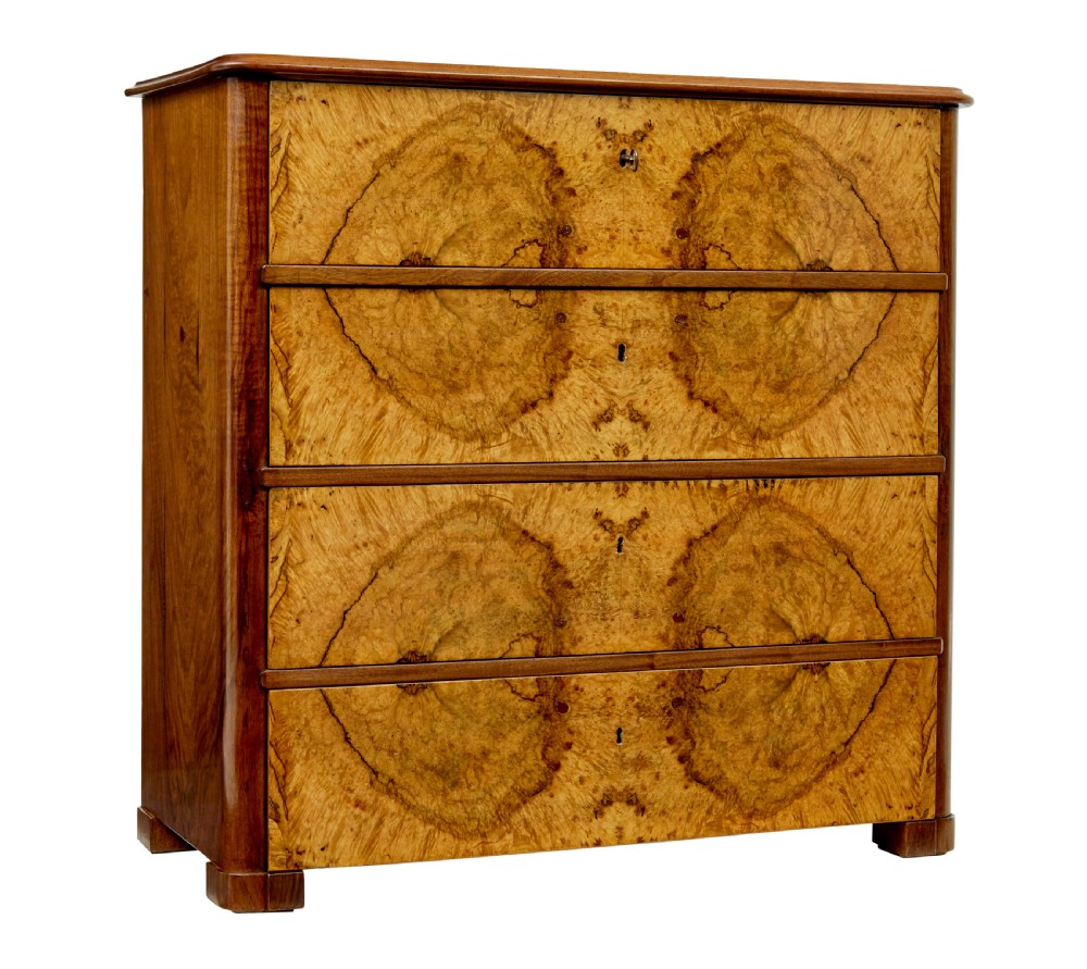 A nineteenth-century Scandinavian burr walnut chest of four drawers featuring symmetrical book-matched grain veneer and rounded side pillars on block feet.