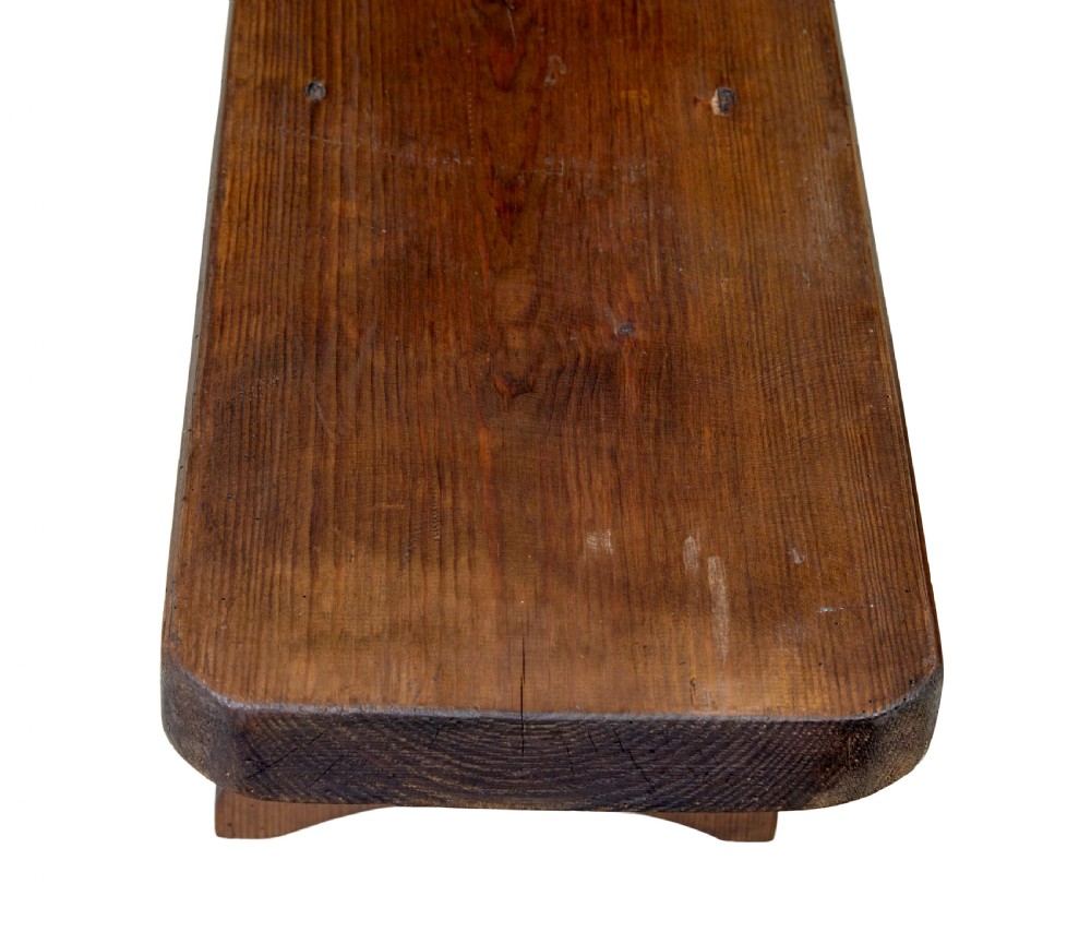 A pair of long early twentieth-century dark pine wooden benches with trestle-style legs. View VII