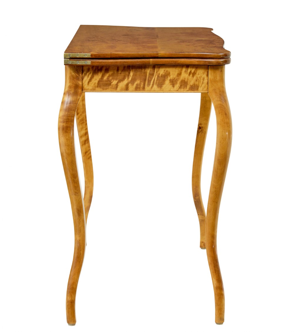A 19th-century Swedish Rococo Revival tea table crafted from highly figured golden birch with cabriole legs and a fold-over top. View VI