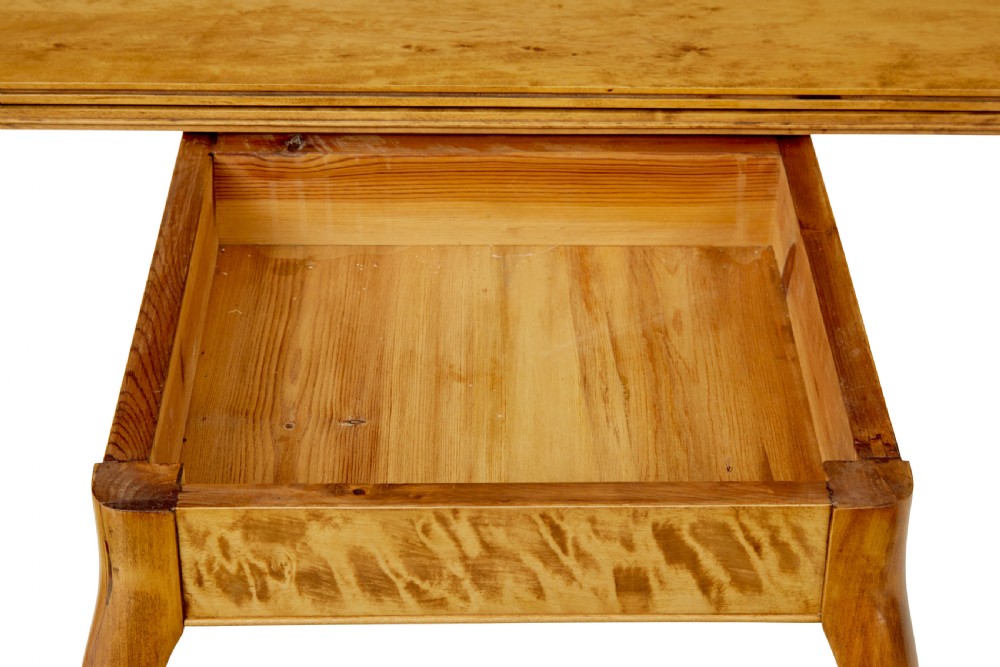 A 19th-century Swedish Rococo Revival tea table crafted from highly figured golden birch with cabriole legs and a fold-over top. View X