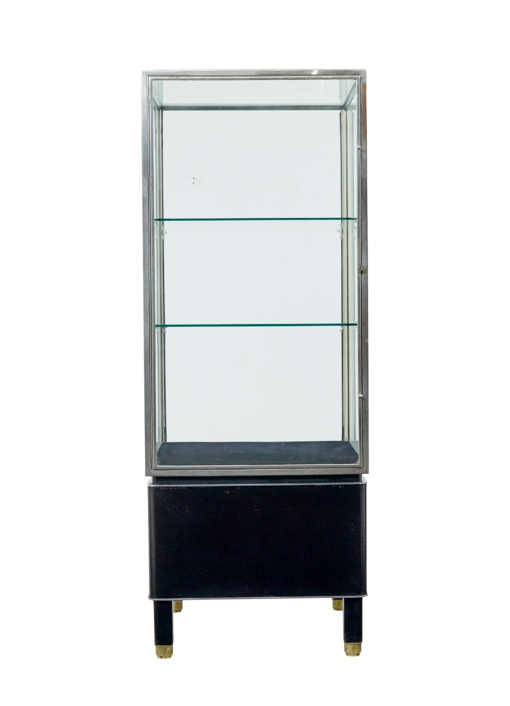 A tall rectangular Art Deco display cabinet featuring transparent glass sides and glass shelves within a thin steel frame, set upon a black leather-clad base with short brass-tipped legs. View III