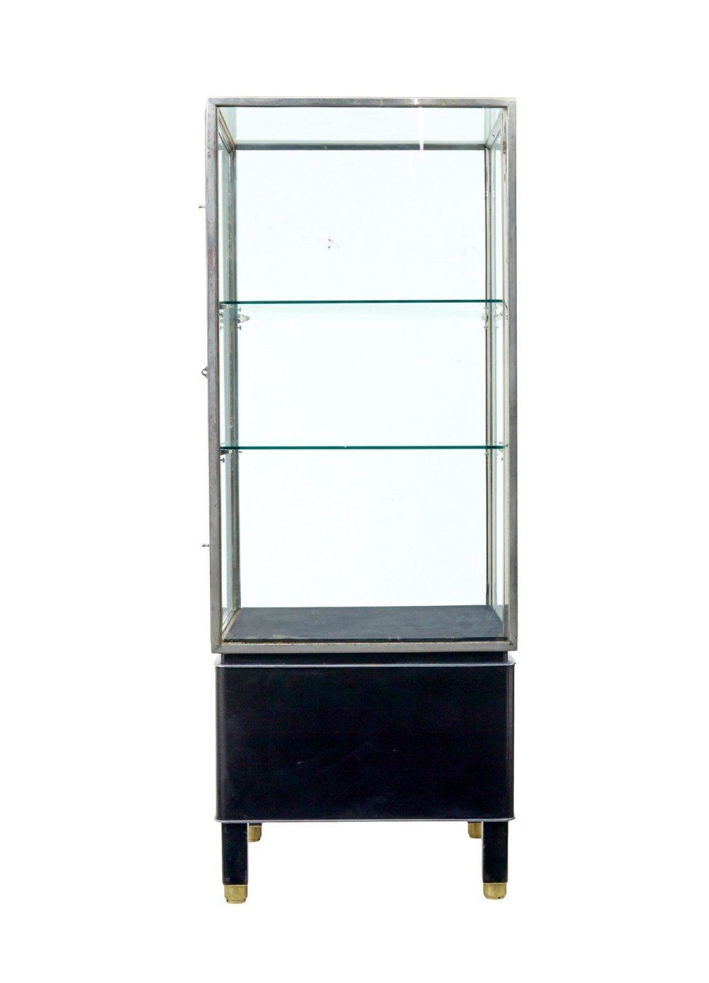 A tall rectangular Art Deco display cabinet featuring transparent glass sides and glass shelves within a thin steel frame, set upon a black leather-clad base with short brass-tipped legs. View IV