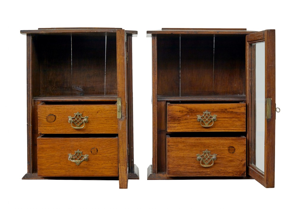 A pair of antique warm brown oak tabletop cabinets featuring glazed doors, brass keyhole escutcheons, and two internal drawers with decorative brass handles. View II