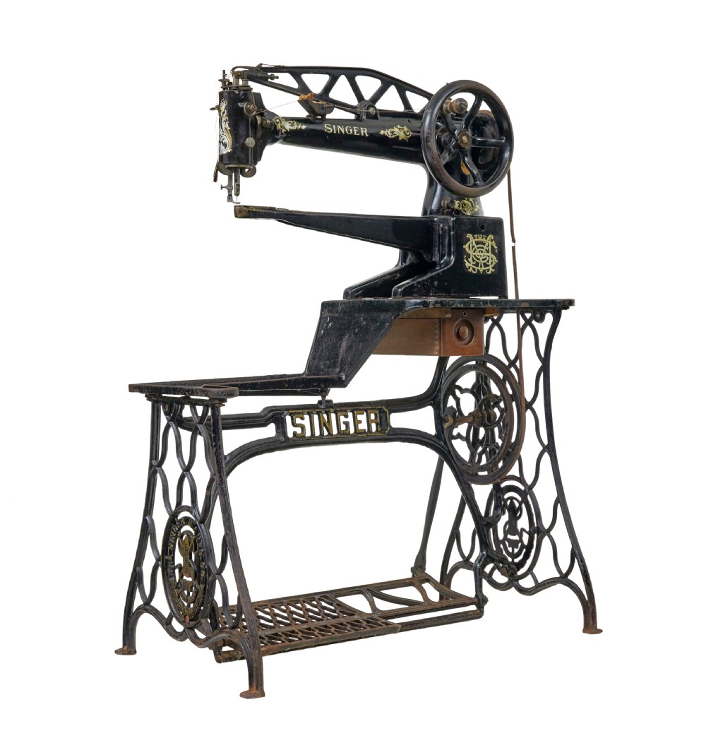 A 19th-century black cast iron Singer industrial treadle sewing machine with openwork frame and gilded lettering.