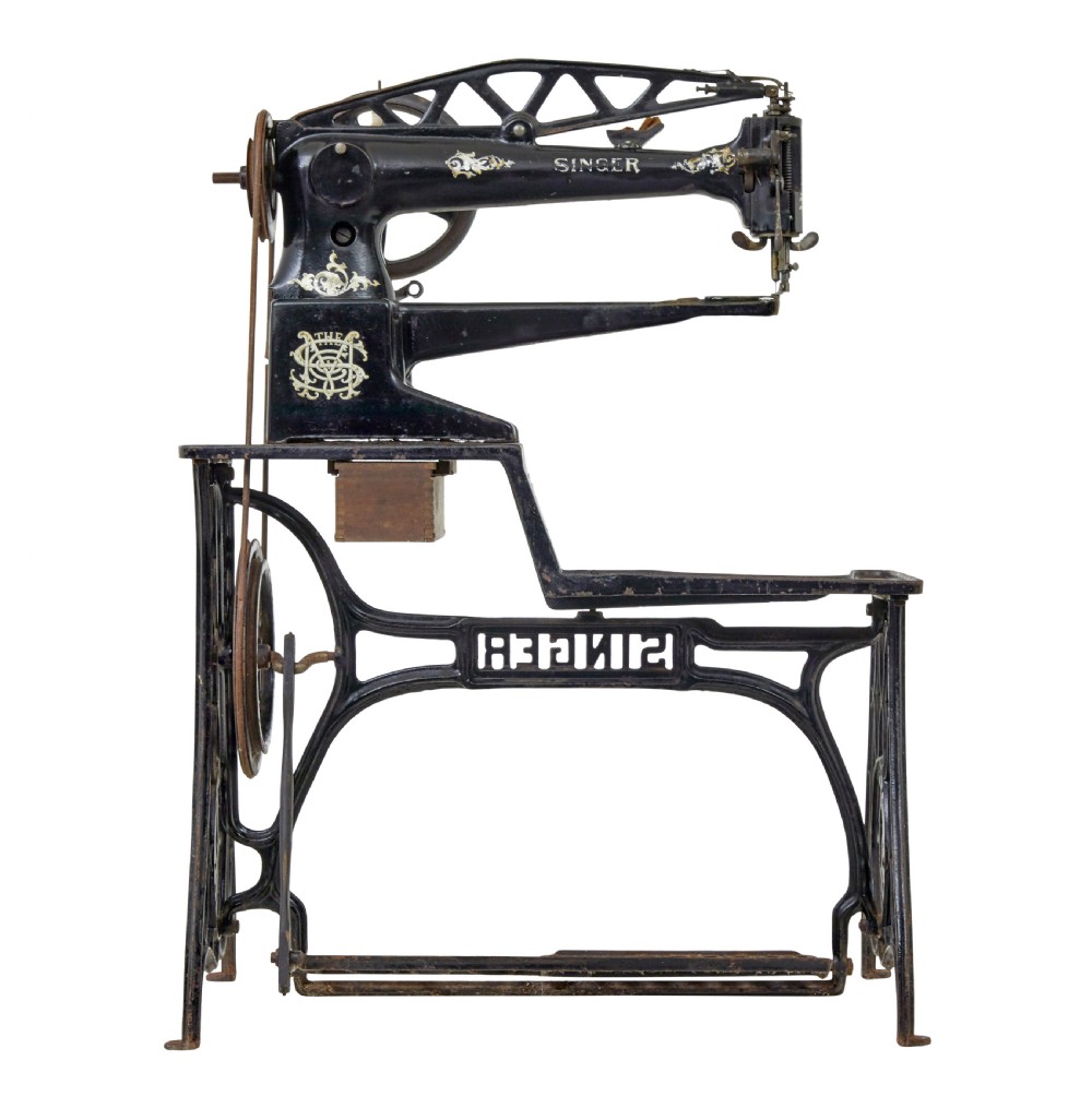 A 19th-century black cast iron Singer industrial treadle sewing machine with openwork frame and gilded lettering. View V