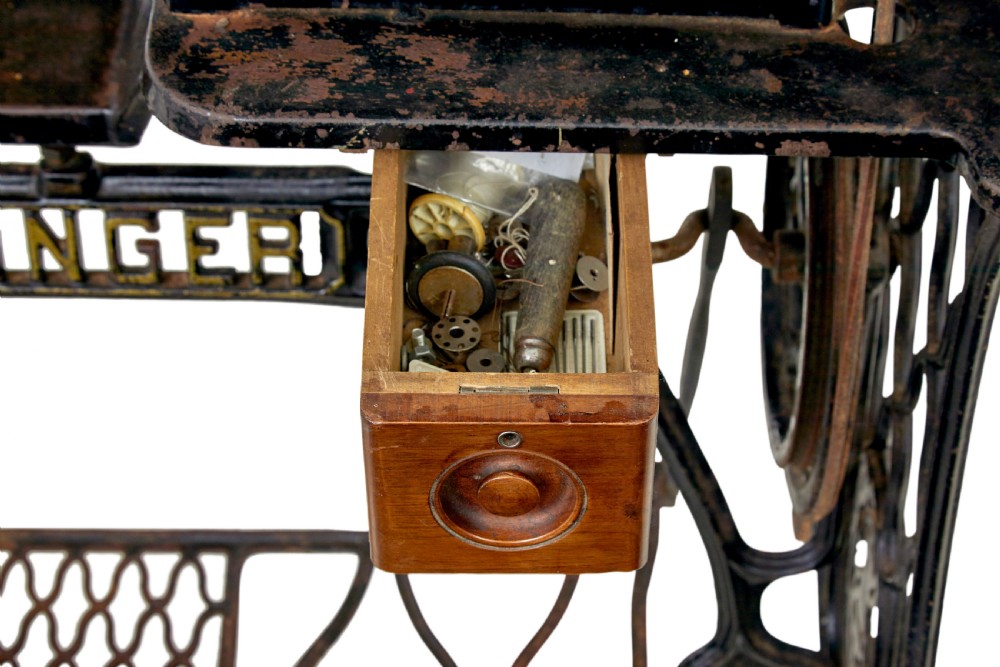 A 19th-century black cast iron Singer industrial treadle sewing machine with openwork frame and gilded lettering. View IX
