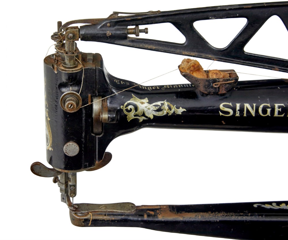 A 19th-century black cast iron Singer industrial treadle sewing machine with openwork frame and gilded lettering. View X