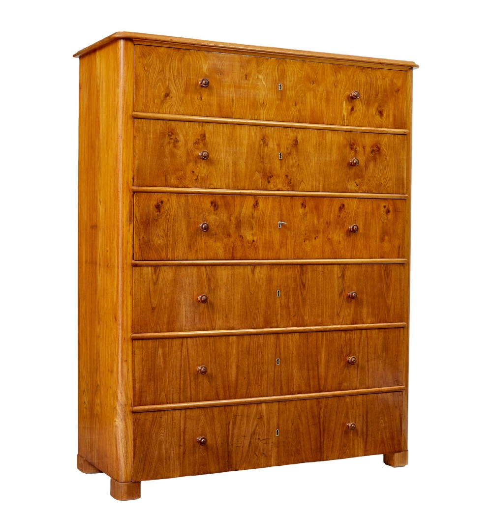 A tall 19th-century elm secretaire chest featuring six graduated drawers with turned wooden knobs and keyhole escutcheons.