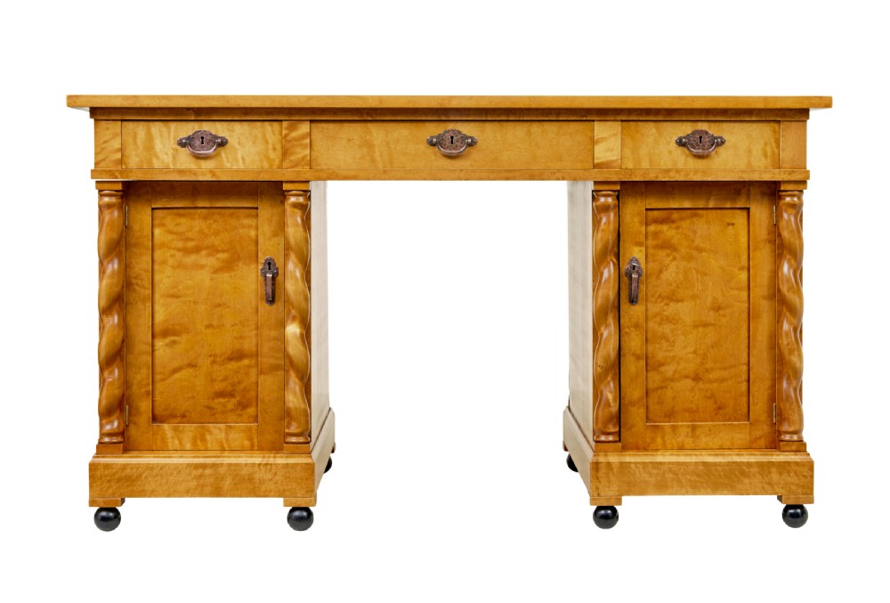 A Swedish early 20th-century pedestal desk crafted from golden flame birch wood featuring barley twist corner columns and spherical black feet. View II