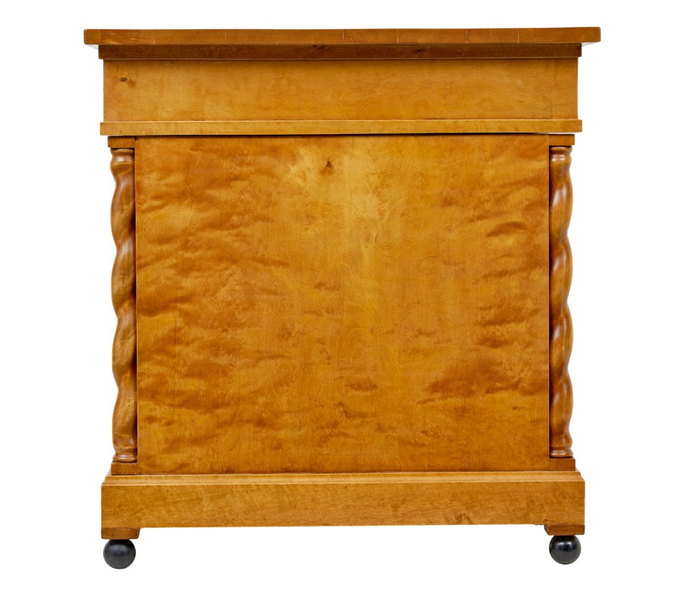 A Swedish early 20th-century pedestal desk crafted from golden flame birch wood featuring barley twist corner columns and spherical black feet. View V