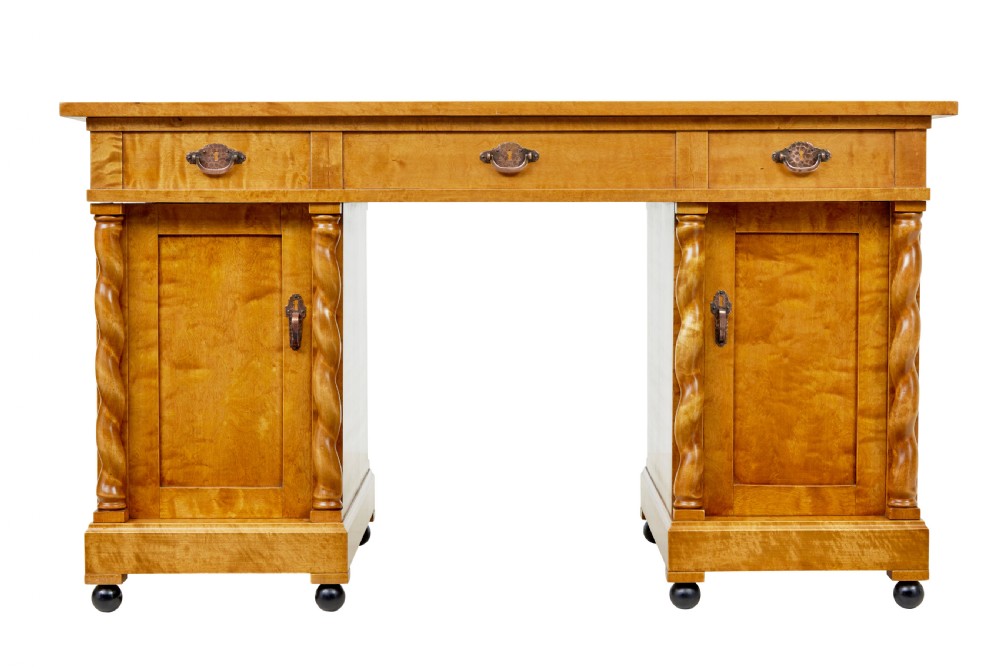 A Swedish early 20th-century pedestal desk crafted from golden flame birch wood featuring barley twist corner columns and spherical black feet. View VI