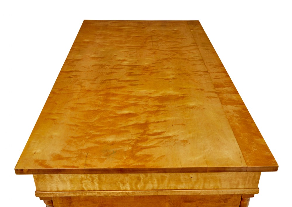 A Swedish early 20th-century pedestal desk crafted from golden flame birch wood featuring barley twist corner columns and spherical black feet. View XI