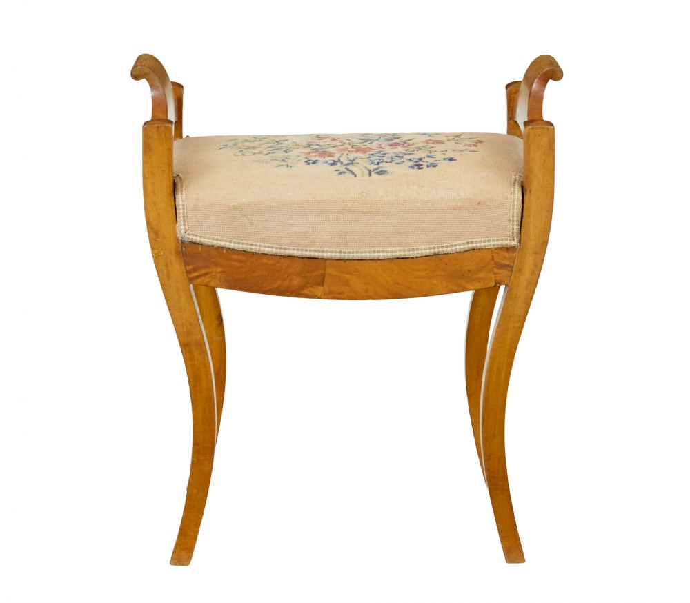 A mid-19th-century Swedish birch Empire stool featuring curved sabre legs, side handles, and a needlepoint upholstered seat with floral embroidery. View III