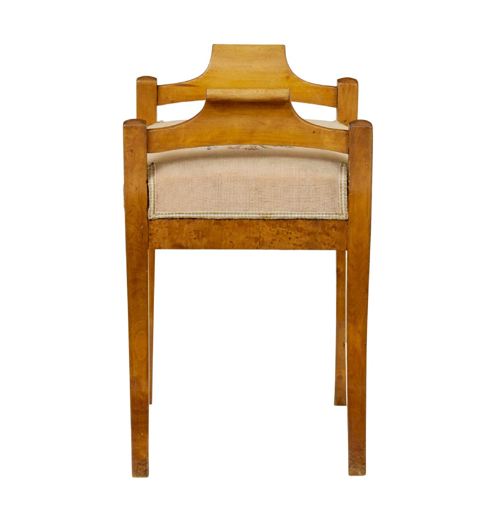 A mid-19th-century Swedish birch Empire stool featuring curved sabre legs, side handles, and a needlepoint upholstered seat with floral embroidery. View VI
