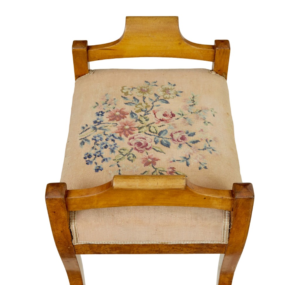 A mid-19th-century Swedish birch Empire stool featuring curved sabre legs, side handles, and a needlepoint upholstered seat with floral embroidery. View VIII