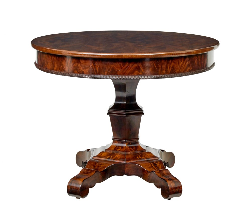 A circular mid-19th-century flame mahogany centre table featuring a frieze drawer, supported by an octagonal pedestal stem and a quadruped scroll-foot base. View V
