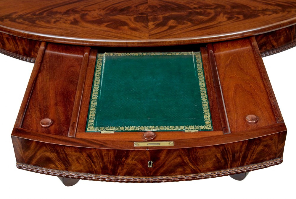 A circular mid-19th-century flame mahogany centre table featuring a frieze drawer, supported by an octagonal pedestal stem and a quadruped scroll-foot base. View VII