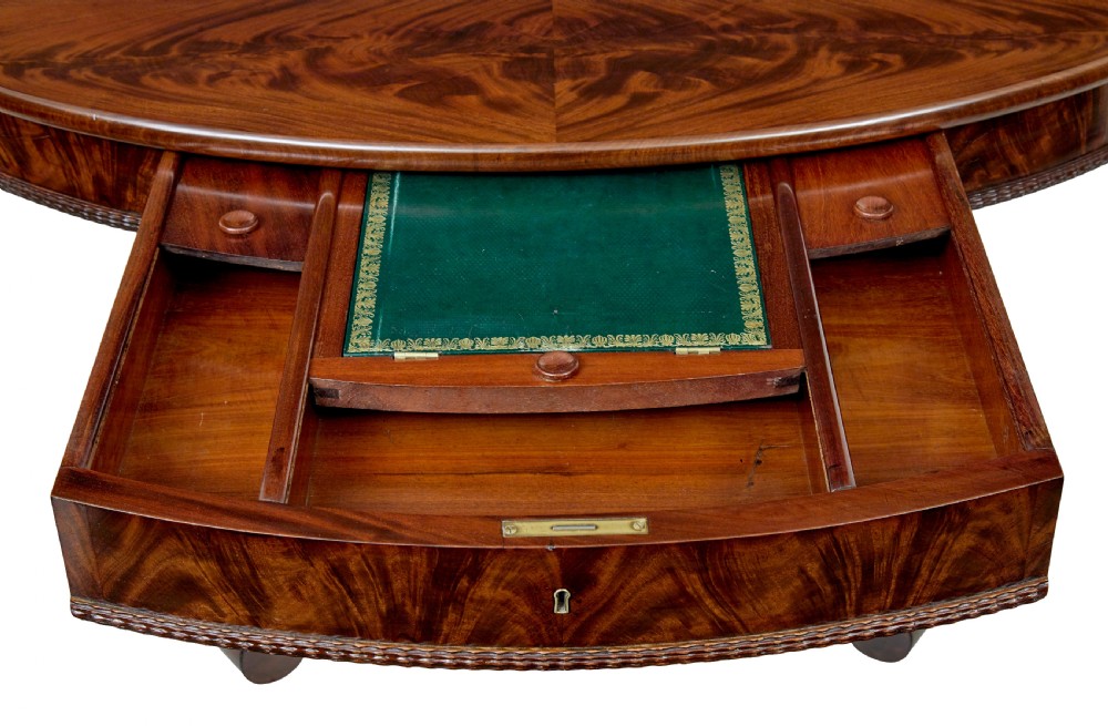 A circular mid-19th-century flame mahogany centre table featuring a frieze drawer, supported by an octagonal pedestal stem and a quadruped scroll-foot base. View VIII