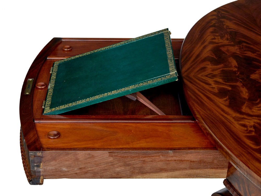 A circular mid-19th-century flame mahogany centre table featuring a frieze drawer, supported by an octagonal pedestal stem and a quadruped scroll-foot base. View X