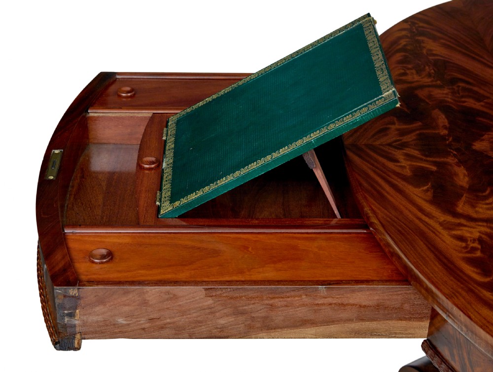A circular mid-19th-century flame mahogany centre table featuring a frieze drawer, supported by an octagonal pedestal stem and a quadruped scroll-foot base. View XI