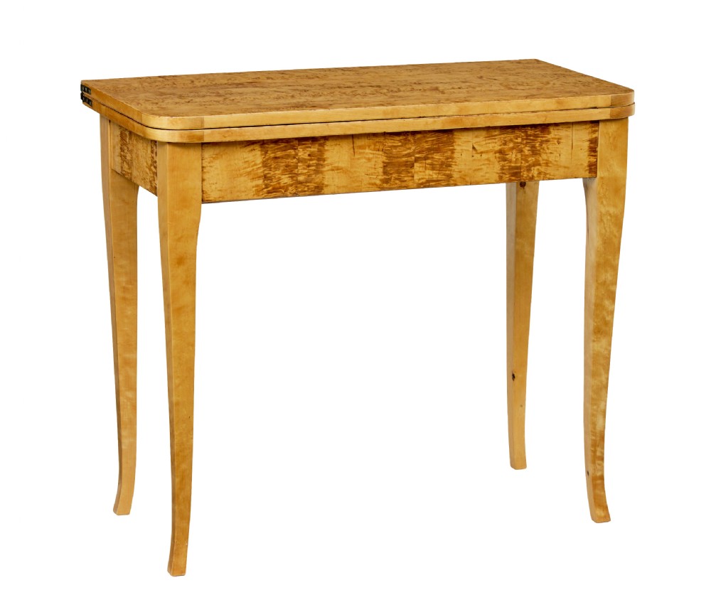 A 19th-century Swedish tea table constructed from warm burr birch veneer featuring slender tapered legs and a folding rectangular top.