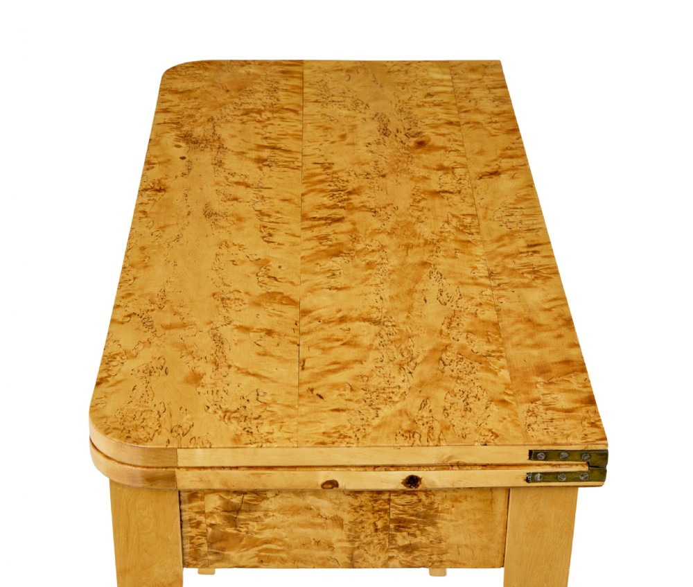 A 19th-century Swedish tea table constructed from warm burr birch veneer featuring slender tapered legs and a folding rectangular top. View II